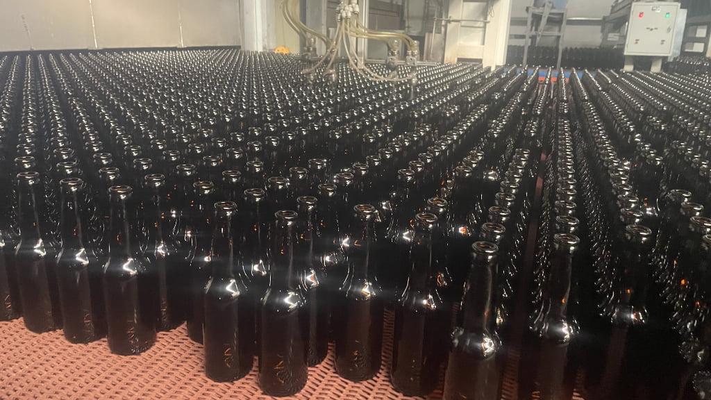 Amber glass beer bottles on production line at Misa Glass manufacturing facility
